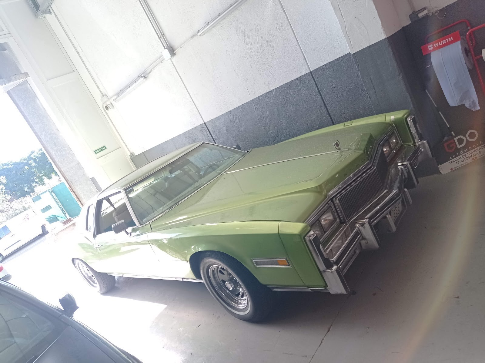 Coche clásico dentro del taller, en proceso de puesta a punto.